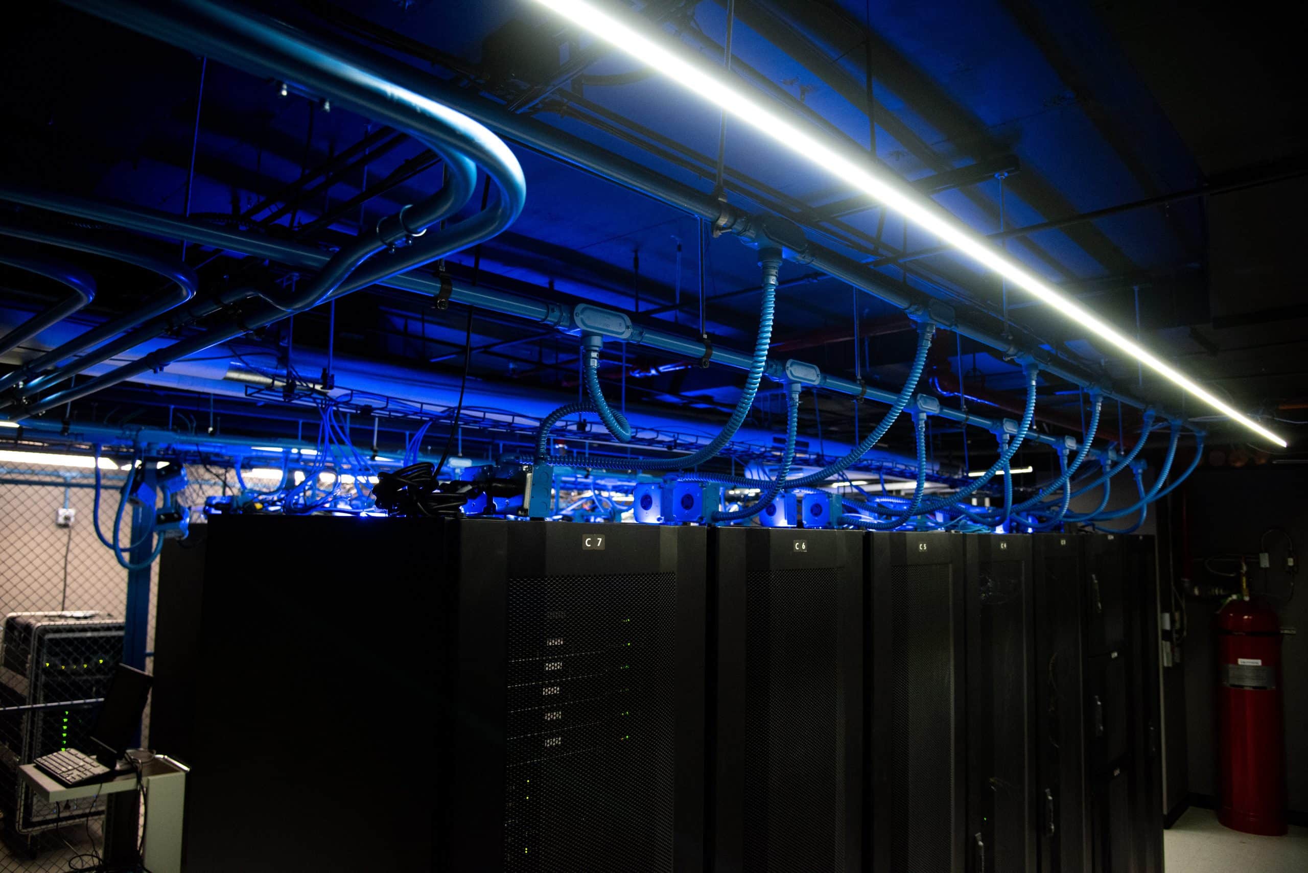 A cybersecurity server room with blue lights and wires.