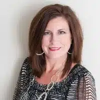 A woman in a black and white top showcasing her leadership qualities.