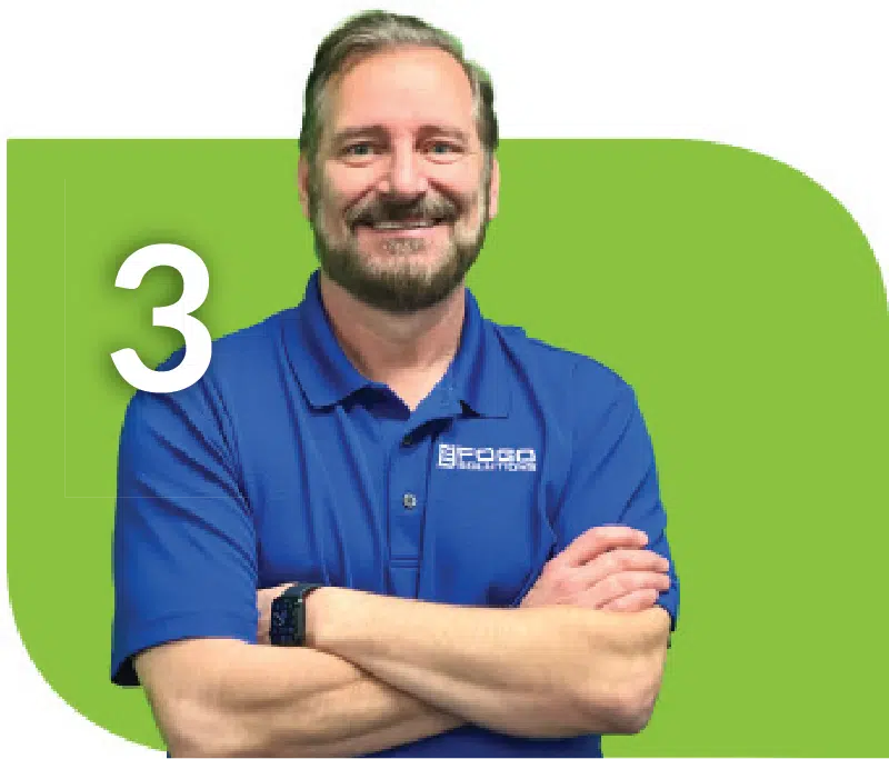 A man in a blue shirt with his arms crossed, against a green background. A man in a blue shirt with his arms crossed, against a green background.