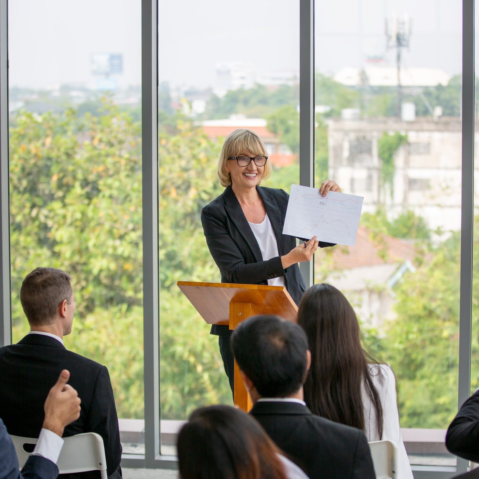 A woman giving a case study presentation to a group of people.